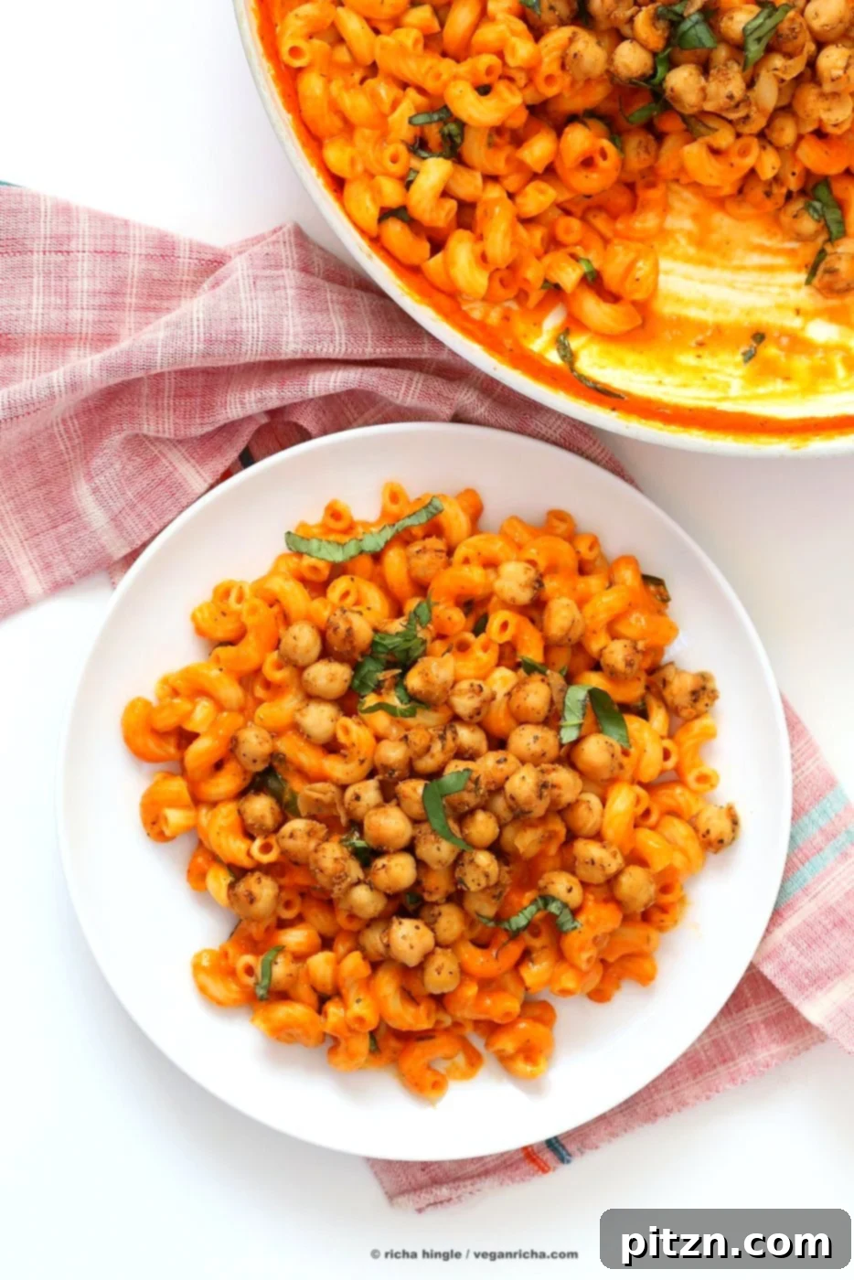 Creamy Roasted Red Pepper Pasta with a Kick of Black Pepper Chickpeas 5 An appetizing overhead shot of the creamy roasted red pepper pasta, ready to be served, garnished generously with crispy black pepper chickpeas and fresh green basil leaves.