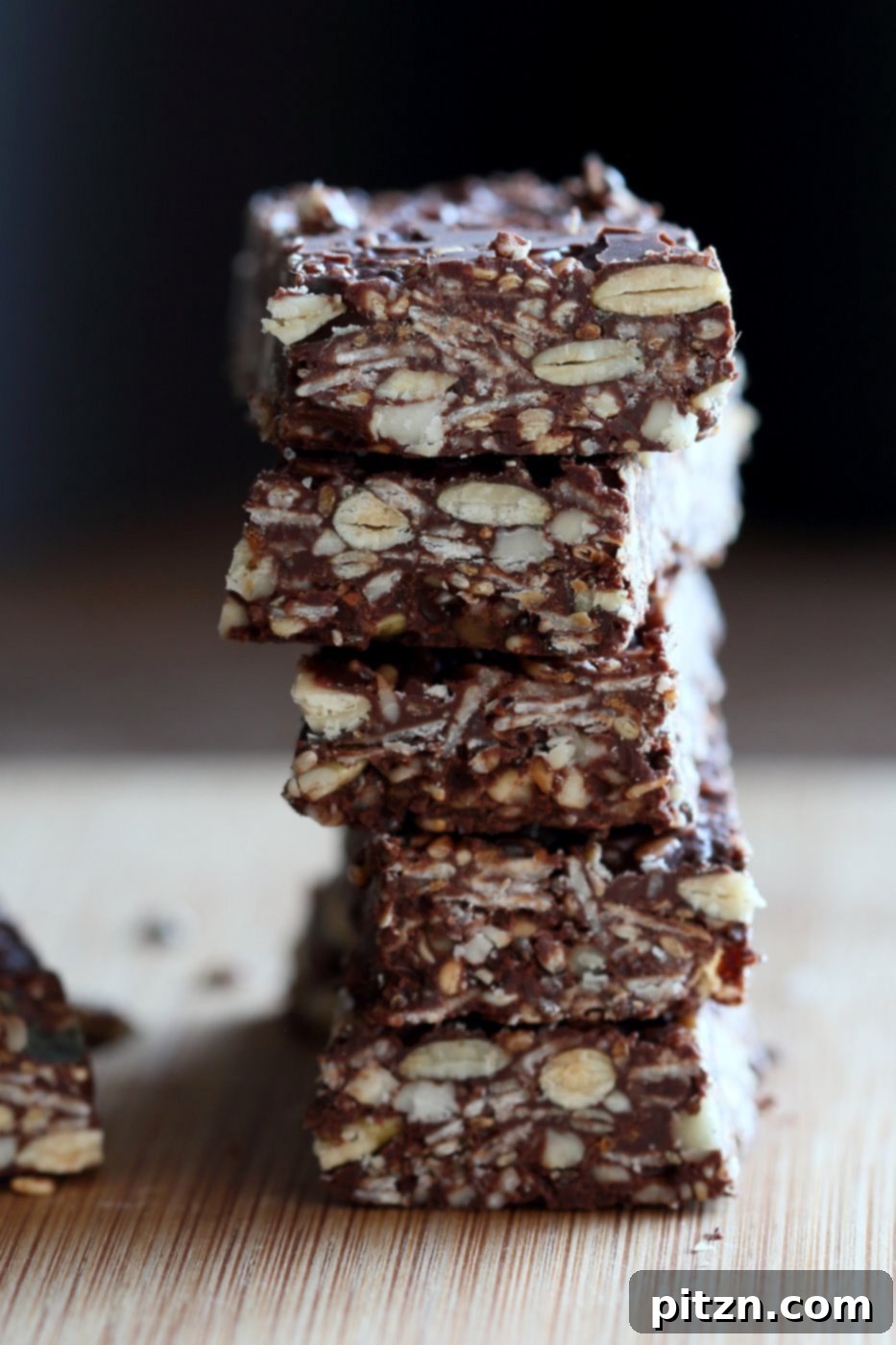 Seeded Ginger Chocolate No Bake Granola Bars 3 Close-up of Super Seedy Chocolate No Bake Granola Bars, highlighting the mix of nuts, seeds, and chocolate. This image emphasizes the homemade quality and rich texture of these easy, healthy, vegan, and gluten-free snacks, perfect for a nut-free diet with seed substitutions. Also features candied ginger and gingerbread spices.