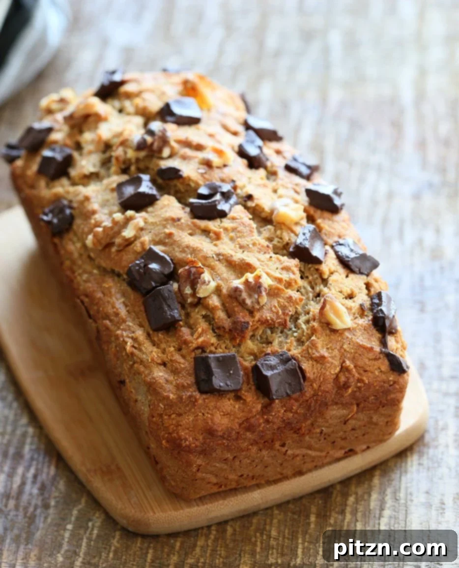 Freshly baked super moist Vegan Banana Bread with toasted walnuts and coconut, cooling on a wire rack. 