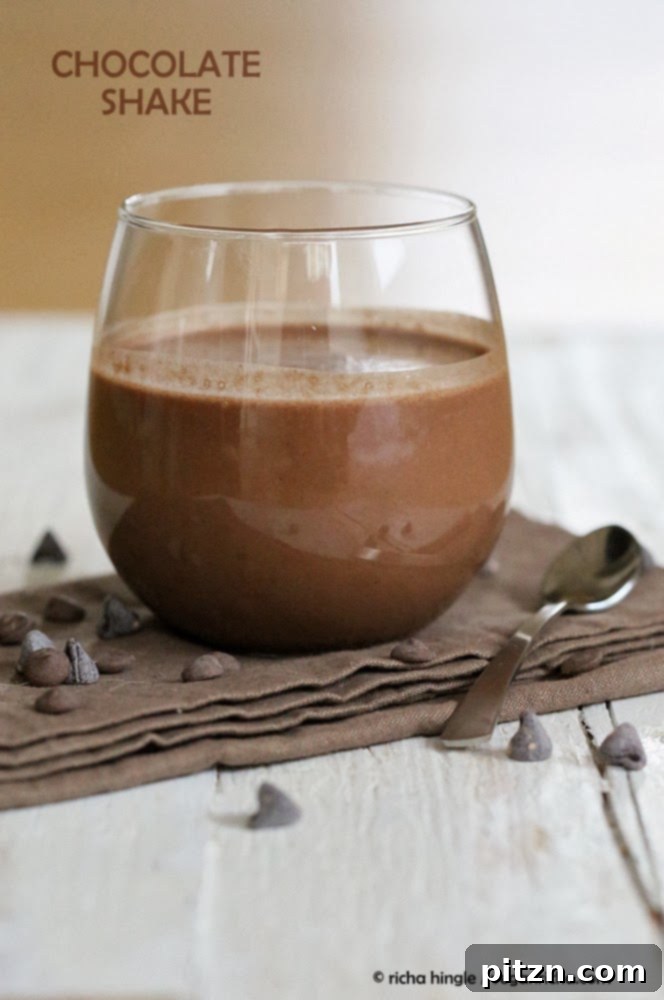 Vegan Chocolate Milkshake with Chocolate Chips Side view of a glass of healthy vegan chocolate milkshake, garnished with chocolate chips on the side, emphasizing its rich texture