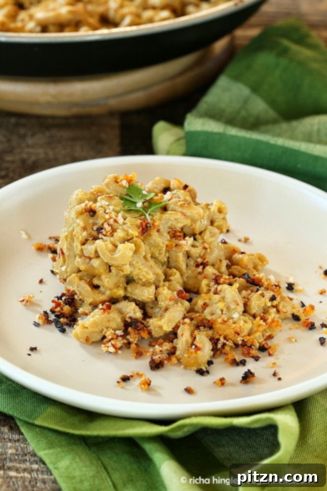 a half-eaten serving of Spicy Cajun mac and cheese on a white plate