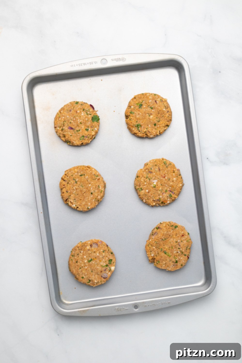 chickpea burger overhead shot of vegan chickpea burger patties lined up on a cookie sheet