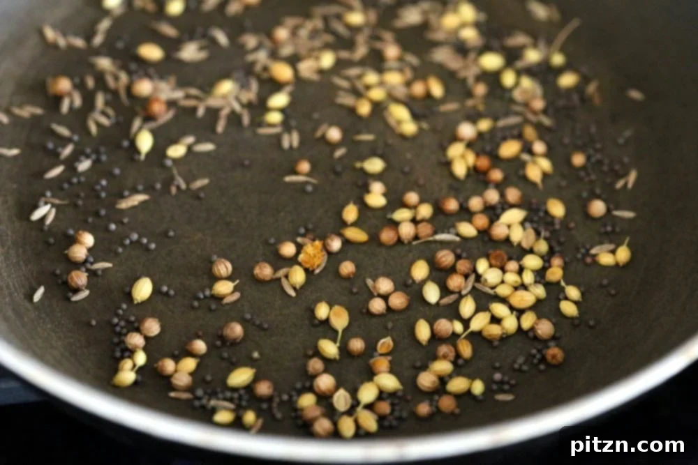 Toasting whole spices for the masala eggplant curry stuffing, a crucial step for enhancing flavor.