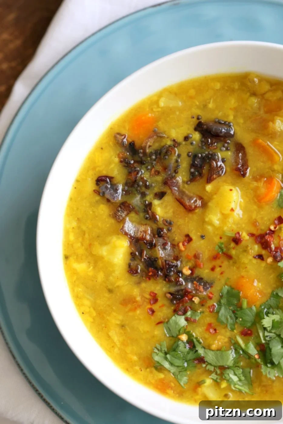 Close-up of a rich Lentil Veggie Dhansak, showcasing the vibrant texture of lentils and vegetables, simmered with traditional Parsi spices. Served hot and fresh. Vegan, Gluten-free, Indian Recipe.