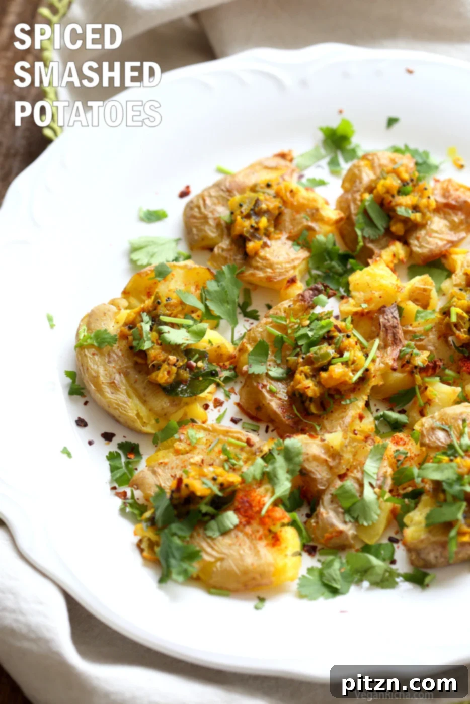 Spiced Smashed Potatoes with a Mustard Ginger Infusion 2 Crispy Indian Spiced Smashed Potatoes, garnished with fresh herbs and lemon wedges, topped with an aromatic mustard-ginger tempering. A healthier vegan and gluten-free snack inspired by Bonda and Samosa.
