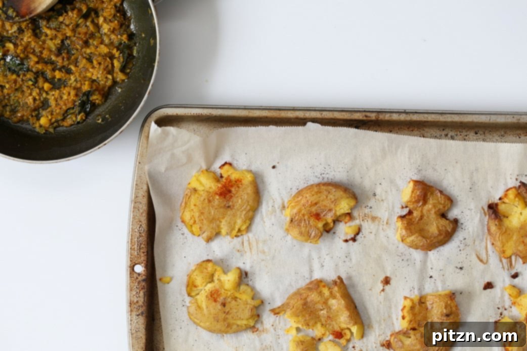 Spiced Smashed Potatoes with a Mustard Ginger Infusion 8 Crispy smashed potatoes arranged on a serving plate, generously topped with the vibrant mustard-ginger tempering, ready to be garnished and served.