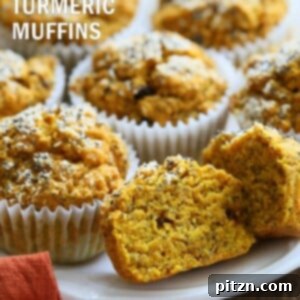 Close-up of a freshly baked Turmeric Carrot Muffin, showcasing its golden color and texture