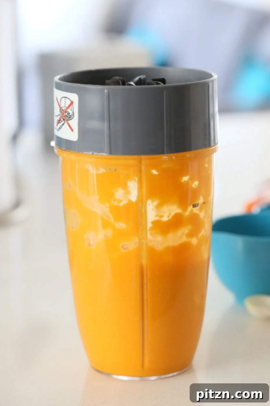 Wet ingredients for Our Vegan Turmeric Carrot Muffins blended in a blender until smooth, featuring carrots, ginger, and turmeric