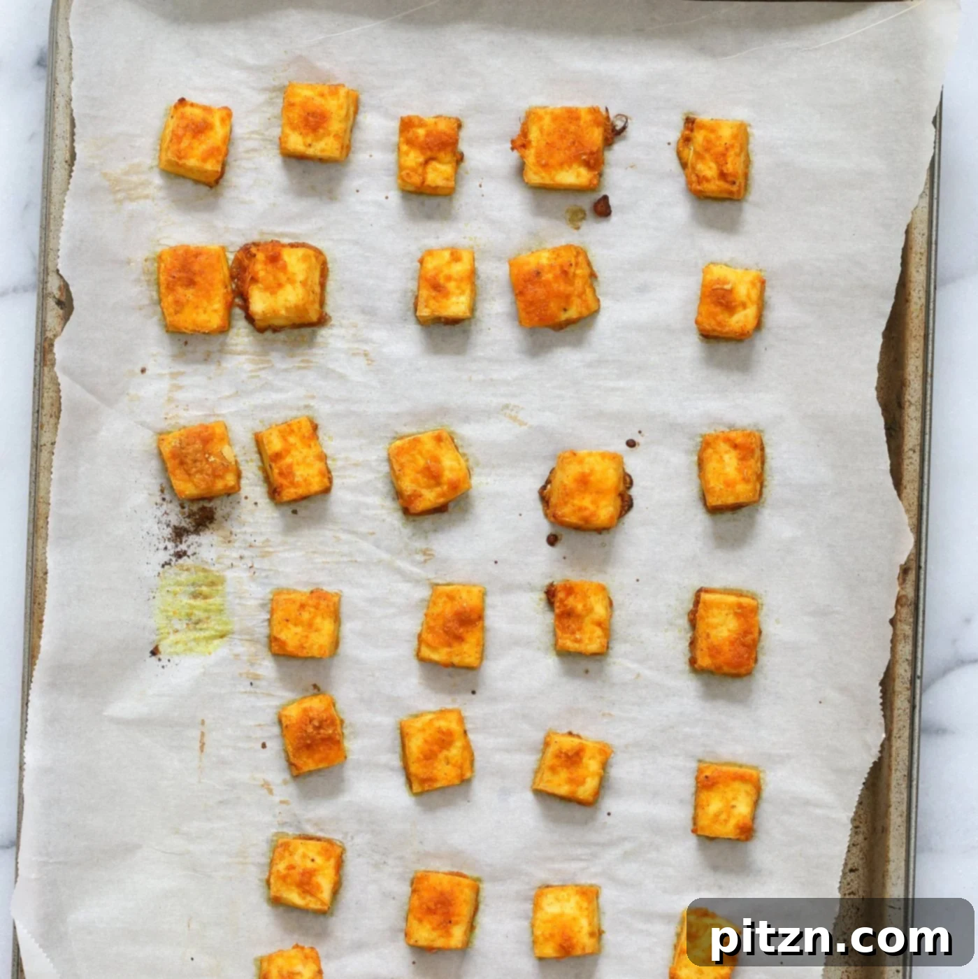 Marinated Tofu Cubes baked on Parchment lined baking sheet for Indian Butter Tofu Masala dish