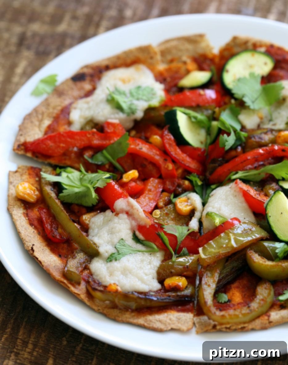 A vibrant, close-up shot of the finished Vegetable Fajita Tortilla Pizza, garnished with fresh cilantro and a sprinkle of red pepper flakes, ready to be enjoyed.