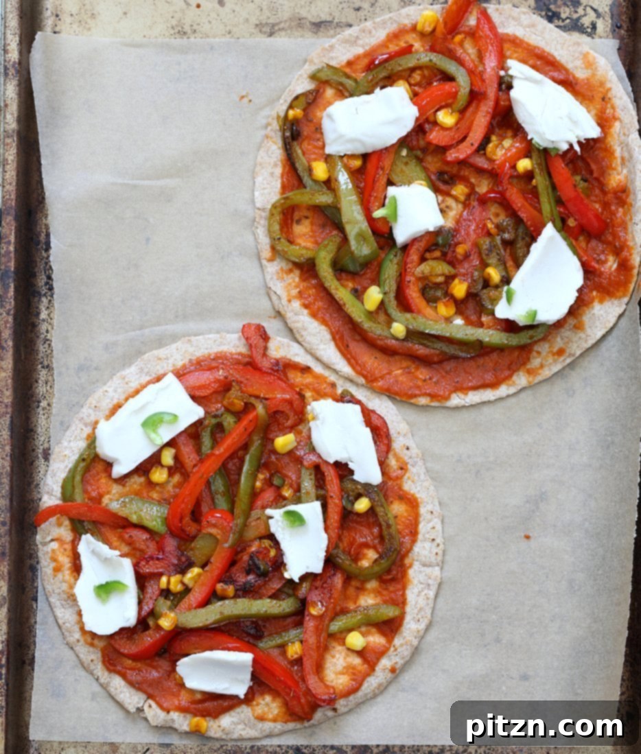 Unbaked Vegetable Fajita Tortilla Pizza, showing the arranged fajita vegetables and vegan cheese on a tortilla base, ready for the oven or grill.