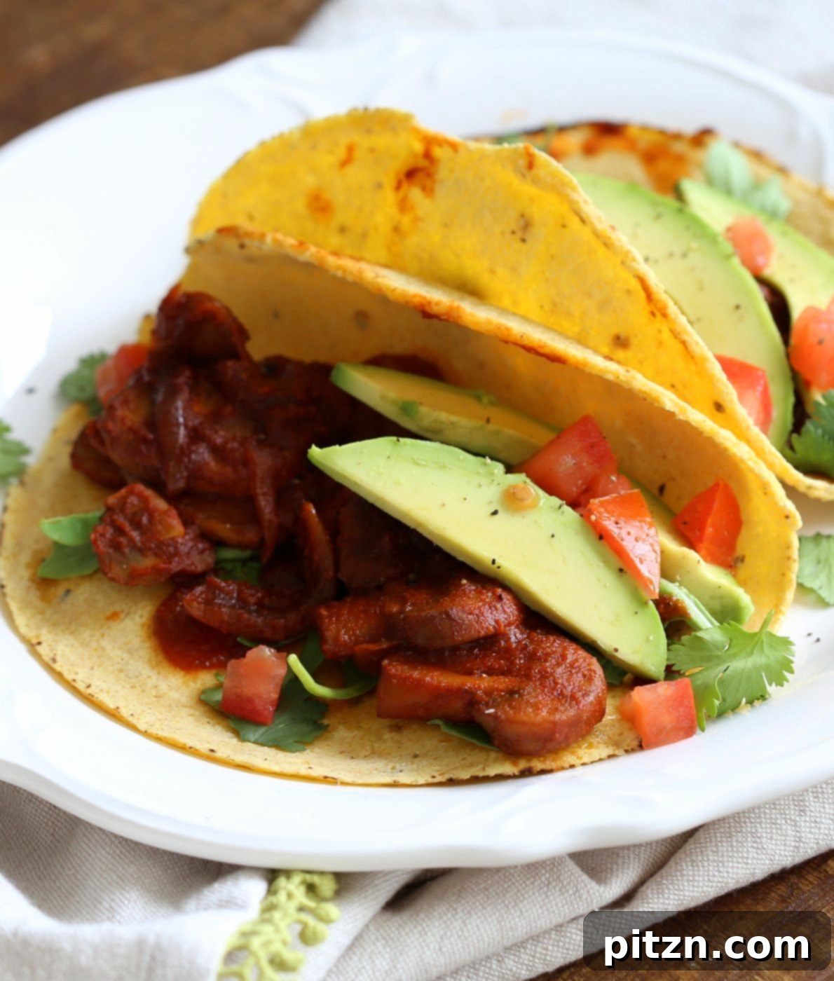 A plate of freshly prepared Vegan Barbacoa Mushroom Tacos, ready to be enjoyed as a vibrant and delicious meal.