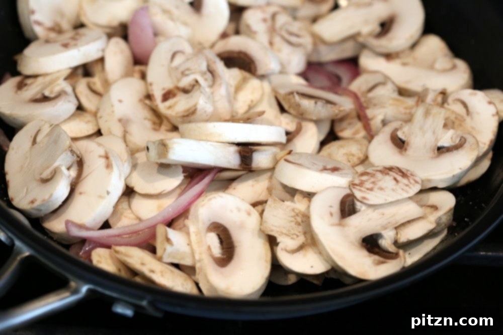 Cooking mushrooms in skillet for Vegan Barbacoa Tacos
