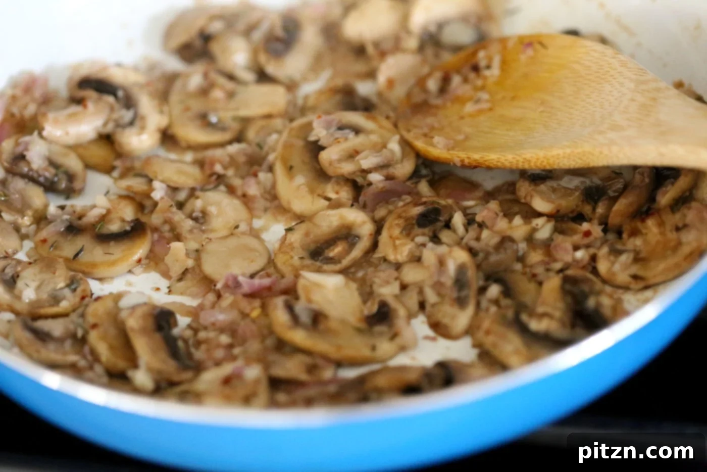 Velvet Vegan Mushroom Alfredo Fettuccine 4 Sautéing onions and garlic with mushrooms in a skillet to achieve golden brown perfection.