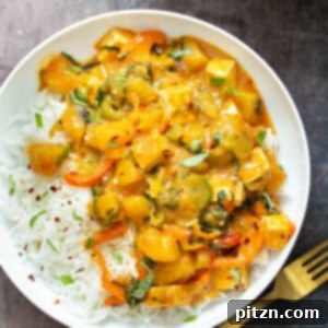 Exotic Thai Pumpkin Curry with tender tofu and a vibrant medley of vegetables, served in a spicy red coconut broth.