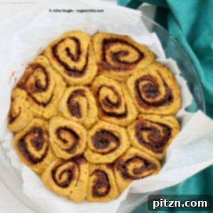 Soft and delicious vegan pumpkin cinnamon rolls, drizzled with glaze.