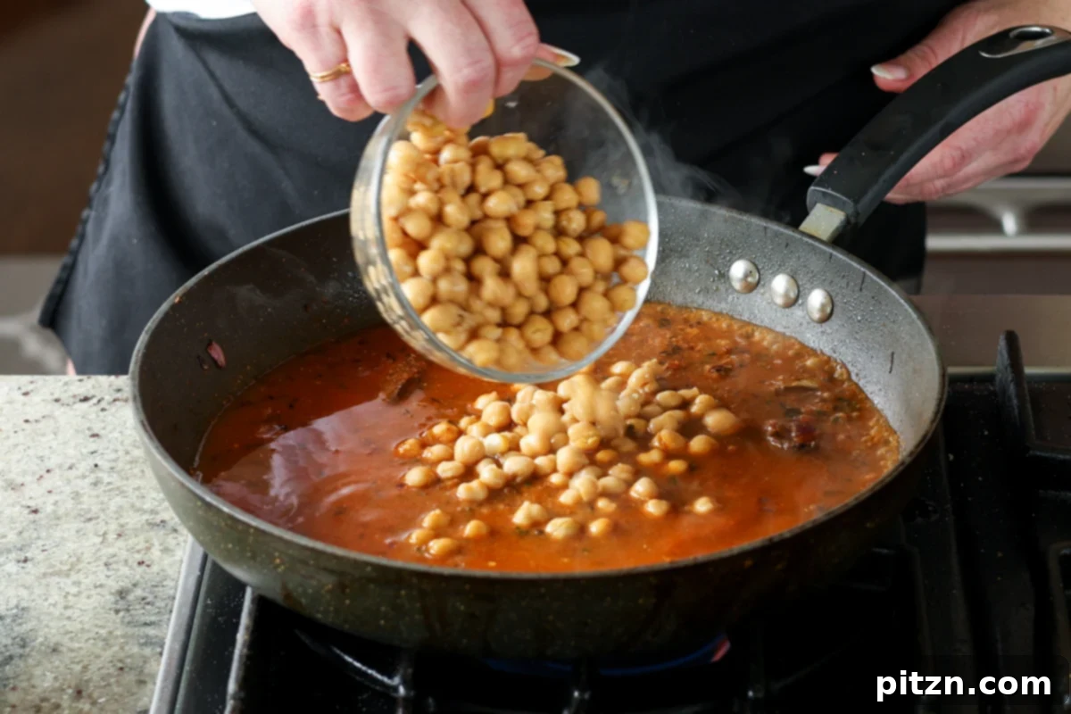 Flavorful Tikki Chole Potato Quinoa Patties and Chickpea Curry 26 adding chickpeas to the pan