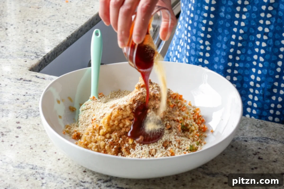 Pouring rich BBQ sauce into the lentil and vegetable mixture, ensuring a deep, smoky flavor for the vegan burgers.