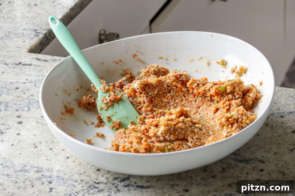 The wet BBQ lentil burger mixture in a bowl, showing the combined lentils, vegetables, and seasonings before adding dry binders.