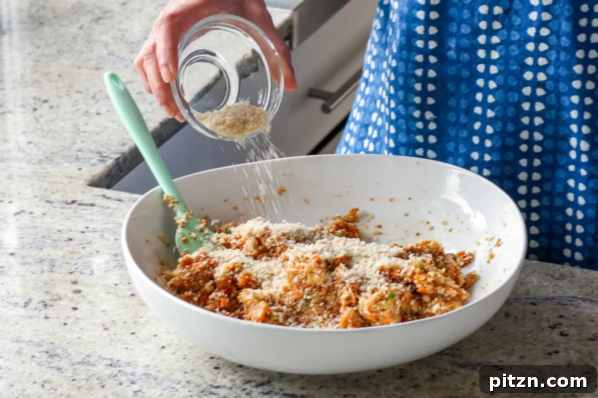 Adding breadcrumbs to the BBQ lentil burger mixture in a bowl, further enhancing its texture and binding properties.