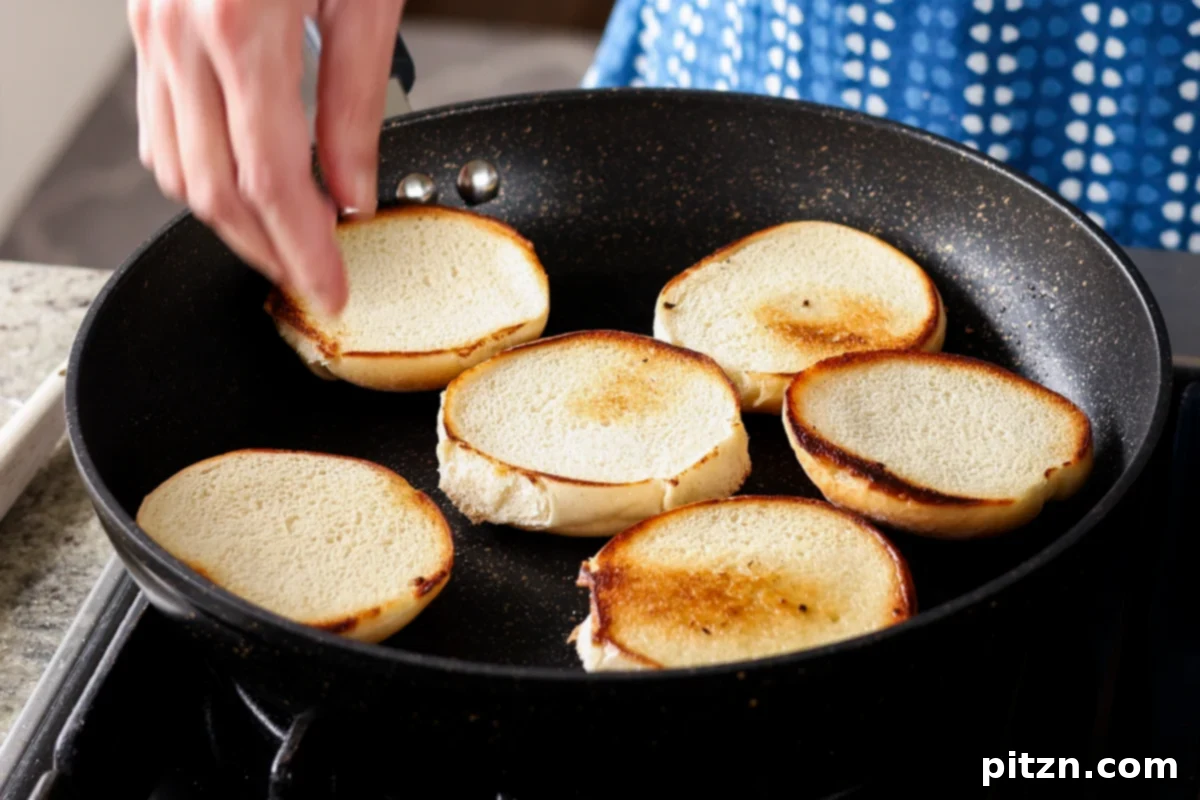 Toasting burger buns in a pan, preparing them for the delicious BBQ lentil burgers.