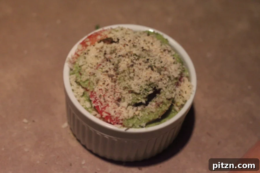 vegan alfredo bake being topped with breadcrumbs before baking