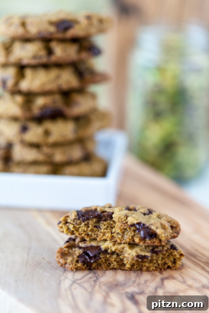 An easy Pistachio Cookies recipe with pistachio butter as the main ingredient and chocolate chunks for extra good flavor! Vegan, Gluten Free. Broken vegan pistachio cookies with chocolate with stack of cookies in background