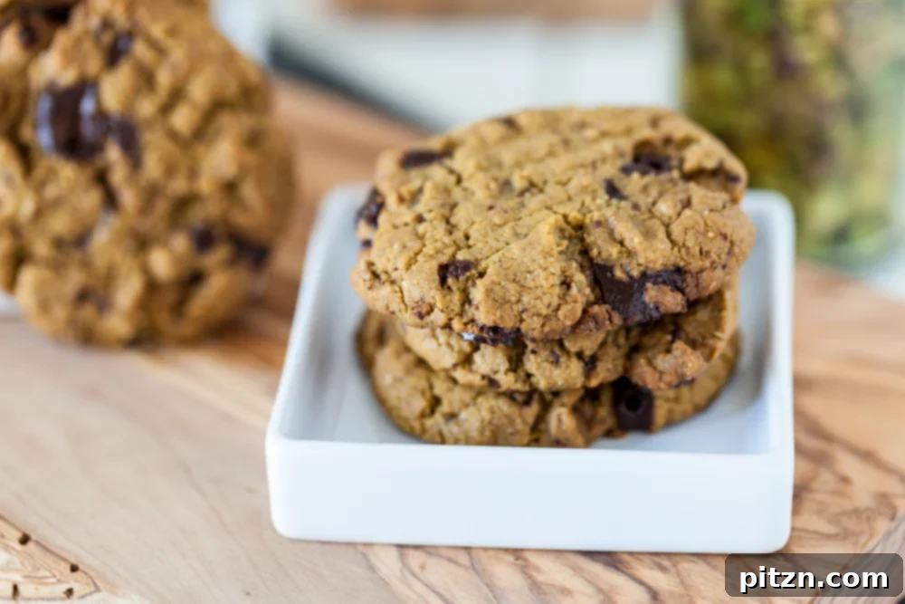 An easy Pistachio Cookies recipe with pistachio butter as the main ingredient and chocolate chunks for extra good flavor! Vegan, Gluten Free. Gluten free pistachio butter cookies on small white plate on wooden board