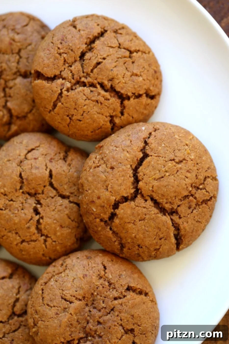 Close-up of crackled top Vegan Pumpkin Ginger Cookies. Soft, sweet, and spiced, these vegan ginger snaps are a perfect plant-based dessert. Gluten-free option available.