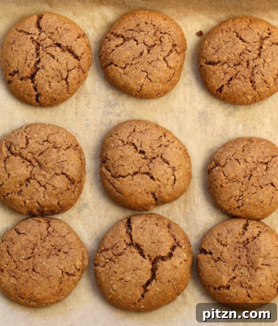 Stack of four Soft Fudgy Vegan Pumpkin Ginger Snaps on a white plate, showcasing their inviting texture. A healthy and delicious vegan cookie recipe.