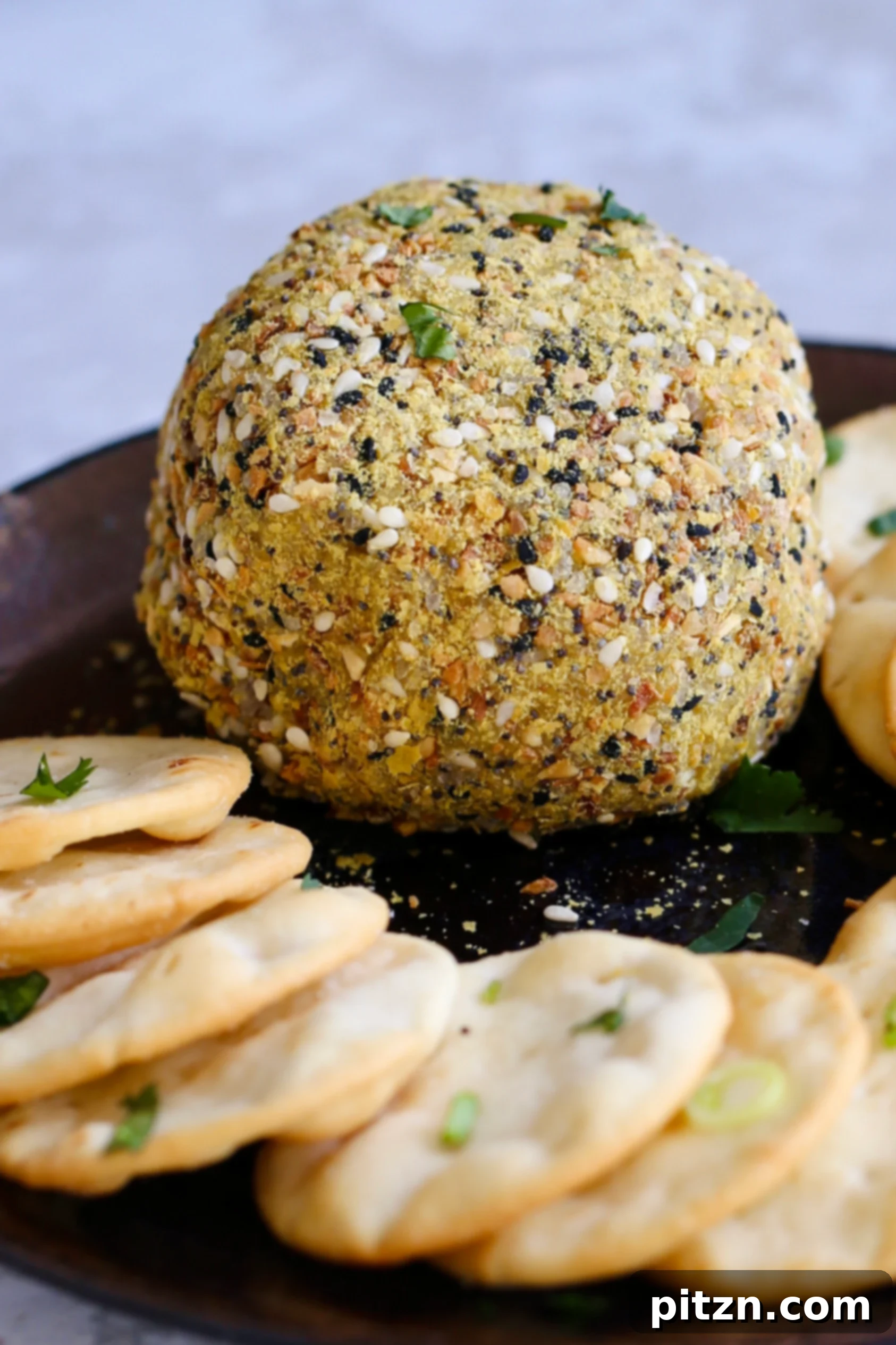 Side view of an Everything Bagel Seasoning coated Vegan Cheese Ball, showcasing its texture and delicious appearance. A perfect 10-minute, gluten-free, and soy-free vegan appetizer.