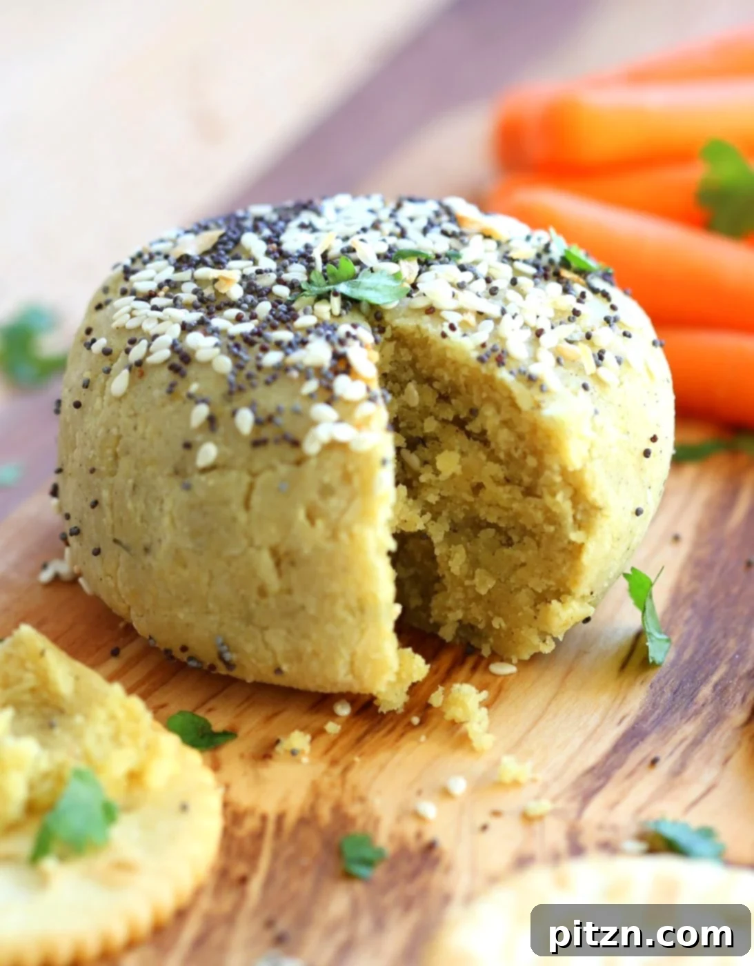Close-up of the Everything Bagel Seasoning Vegan Cheese Ball, showing the delightful coating and creamy texture inside. A perfect gluten-free, soy-free, and quick vegan appetizer.