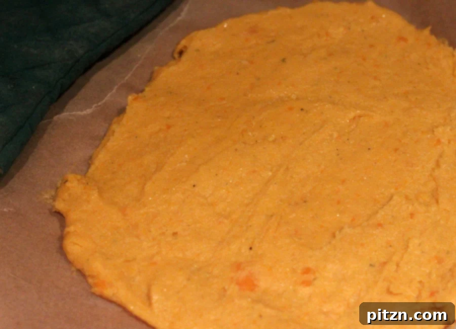 Spreading chickpea kabocha batter on parchment paper