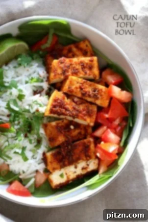 Cajun tofu with cilantro lime rice, baked Cajun spiced tofu served over greens, cilantro lime rice, and tomatoes, creating an easy, spicy vegan bowl that's gluten-free and nut-free. Can be soy-free with chickpea tofu.