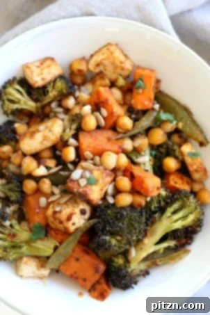 Sheet pan veggie dinner with broccoli, sweet potato, tofu, chickpeas, and sunflower seeds, dressed with a miso maple dressing. Vegan, gluten-free, nut-free, and soy-free adaptable.