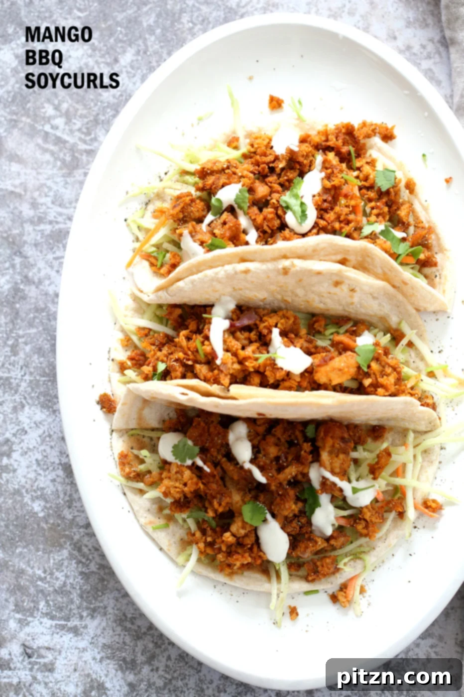 Juicy Mango BBQ Soy Curls in a taco, garnished with fresh cilantro and creamy slaw. This vegan, gluten-free, and oil-free recipe promises a burst of tropical and smoky flavors.
