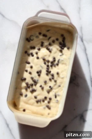 Close-up of a rustic slice of Vegan Chocolate Chip Cake on a white napkin, highlighting the soft texture.