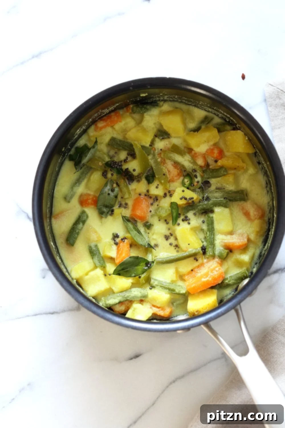 Close-up of Avial, showcasing colorful seasonal vegetables in a rich coconut sauce.