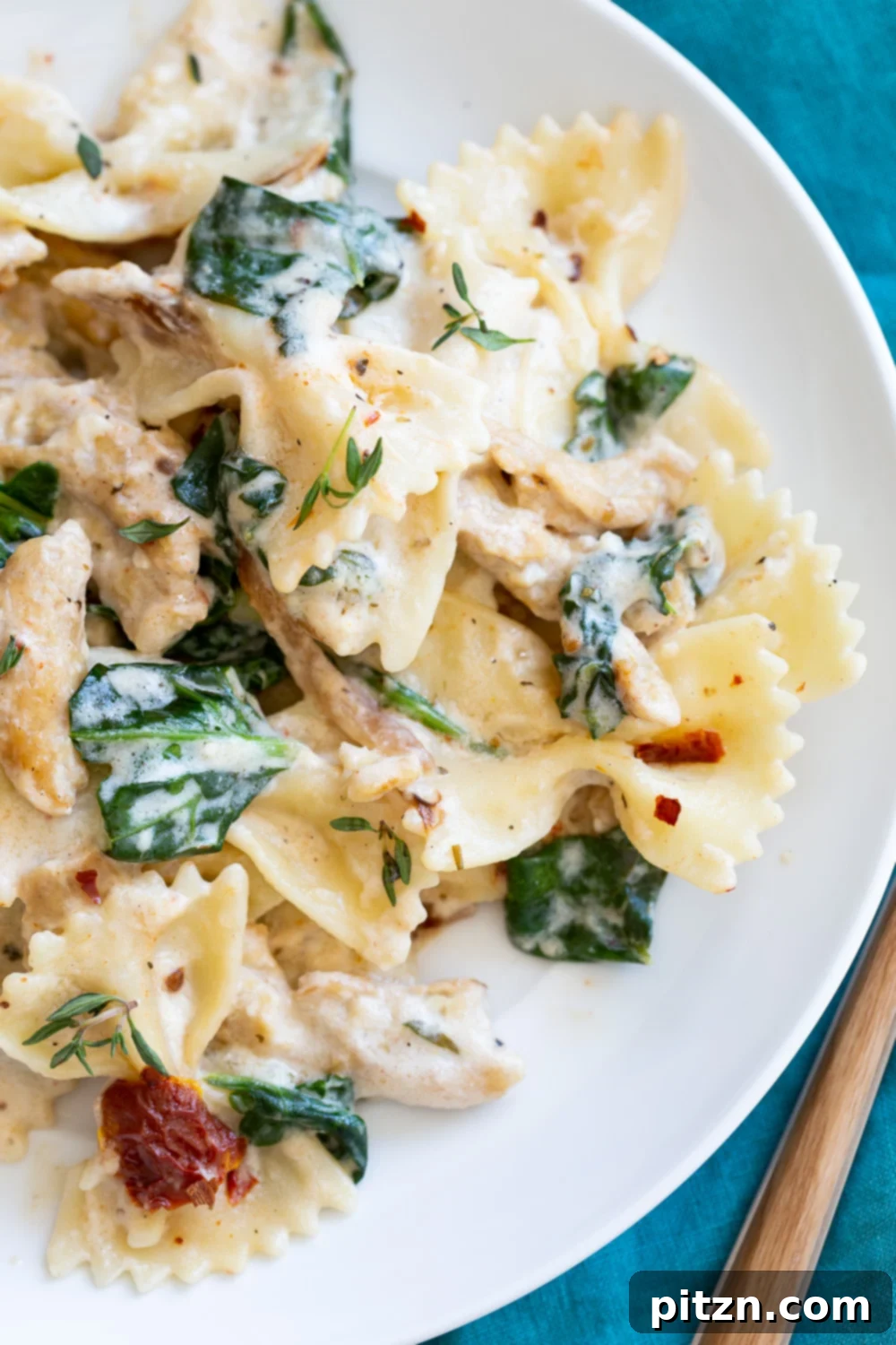 Creamy Sun dried Tomato Pasta in a white plate with fork