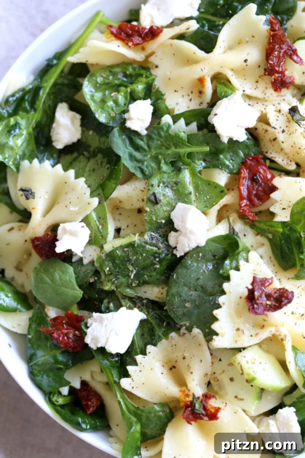 Tuscan Pasta Salad with Zesty Lemon Vinaigrette 4 Close-up view of the Tuscan Pasta Salad, highlighting the fresh spinach, sun-dried tomatoes, and pasta, ready to be tossed with dressing.