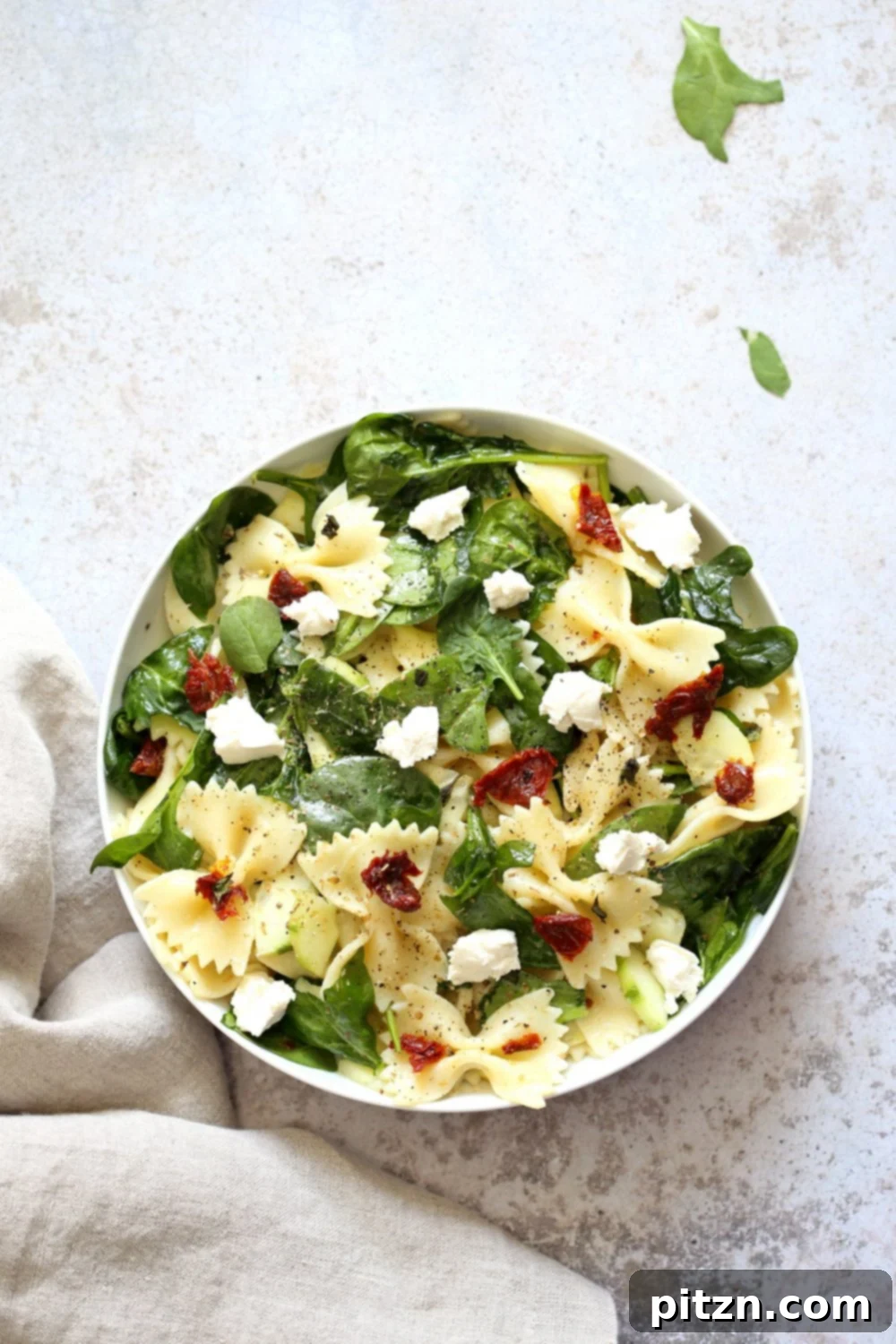 Tuscan Pasta Salad with Zesty Lemon Vinaigrette 5 A bowl of fresh Tuscan Pasta Salad with lemon wedges, ready to be enjoyed.