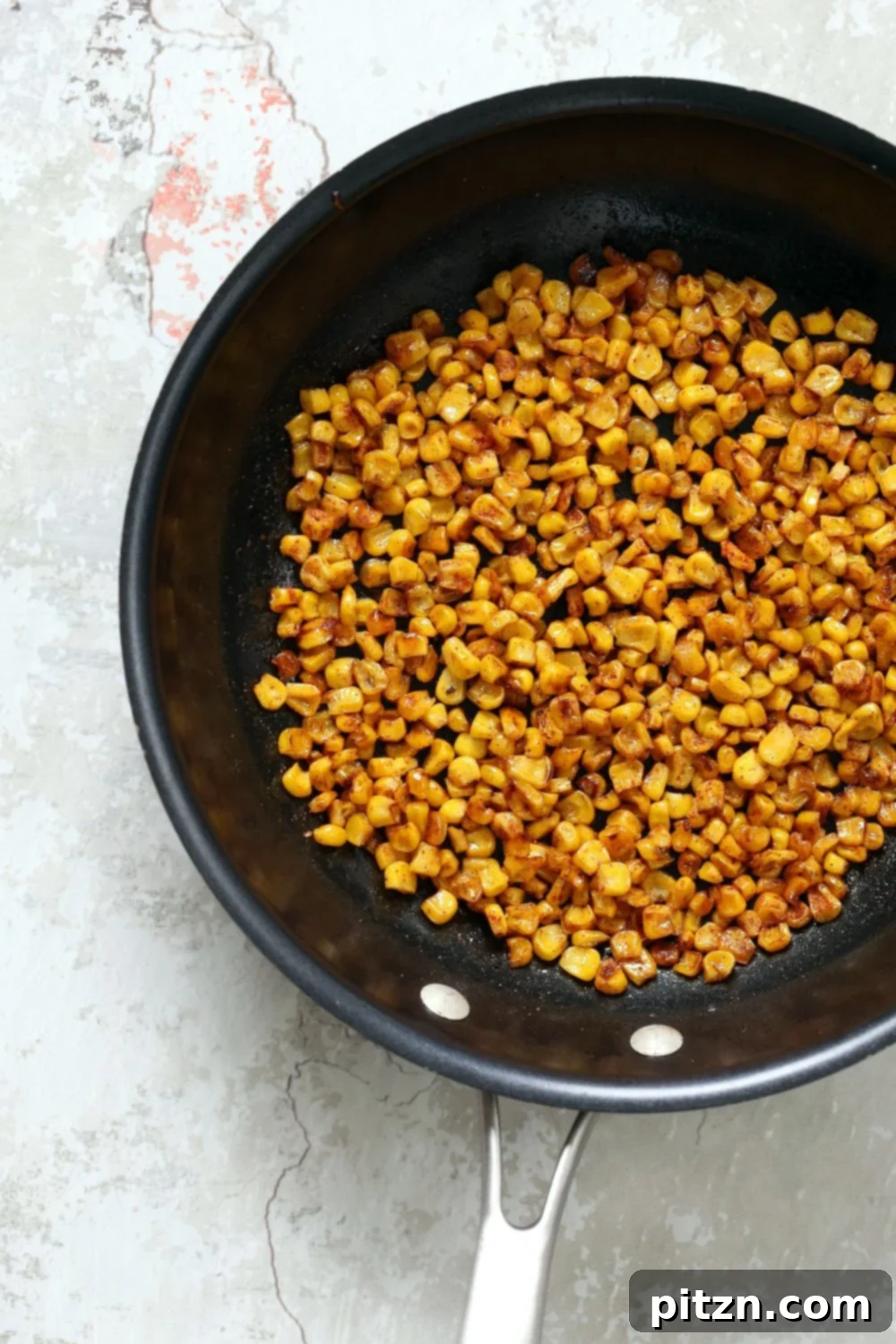 Roasted Corn for our Mexican Street Corn Sala, in a Black Skillet kept over concrete