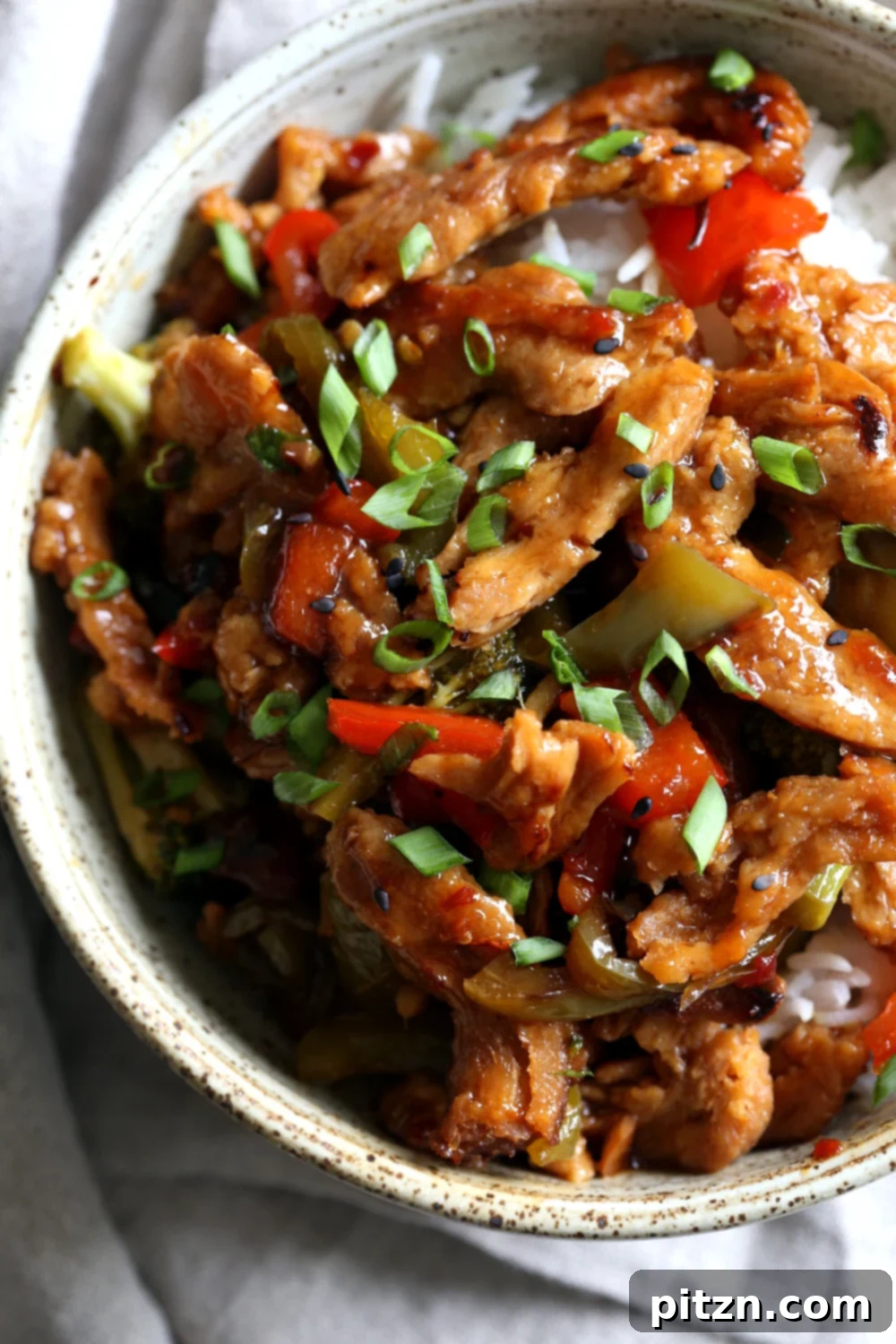 Crispy Vegan General Tso's Soy Curls 7 Full bowl of Vegan General Tso Soy Curls garnished with fresh green onions and sesame seeds, ready to be served