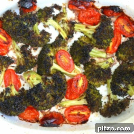 Vibrant Vegan Pesto Pasta with Smoky Charred Broccoli 11 Broccoli florets and cherry tomatoes seasoned with oil, lemon juice, garlic, and red pepper flakes, ready for roasting in a baking dish.