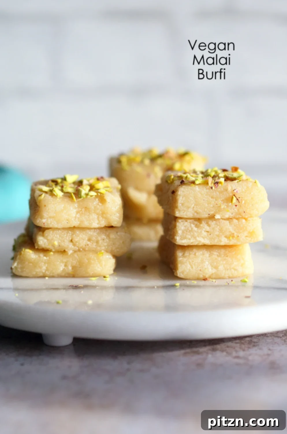 Our delicious Vegan Malai Burfi bars beautifully arranged on a marble surface, showcasing their perfect texture and inviting appearance.
