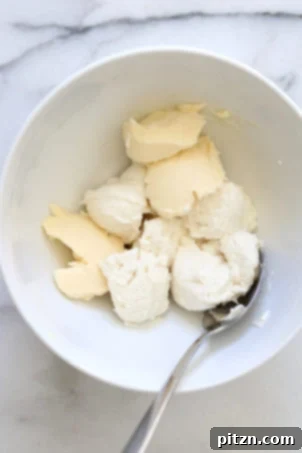 Velvety Vegan Malai Burfi Fudge 4 Whipping vegan cream cheese and butter in a white bowl, the first step in making our Vegan Malai Burfi.