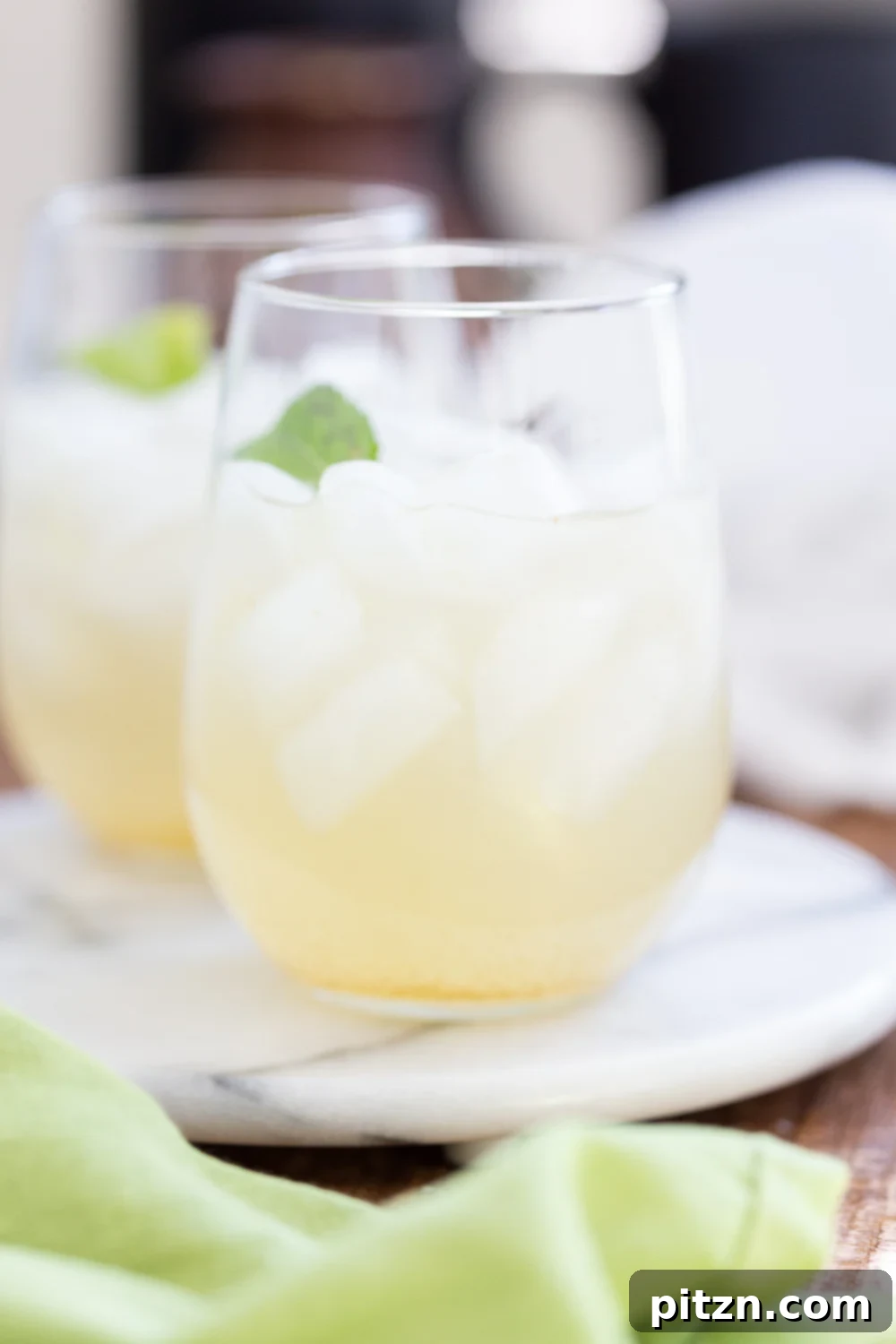 Shikanji Zesty Indian Lemonade 5 Four glasses of Shikanji or Nimbu Pani, Indian Lemonade, with ice, lime slices, and mint leaves, on a light background, highlighting its refreshing appeal.