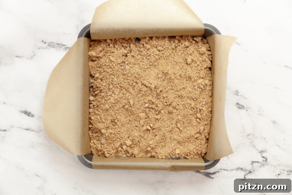 Berry Buckle Batter with streusel in a parchment lined baking dish