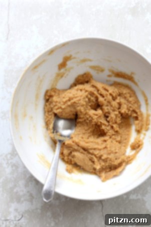 Mixing wet and dry ingredients to form vegan cookie dough.