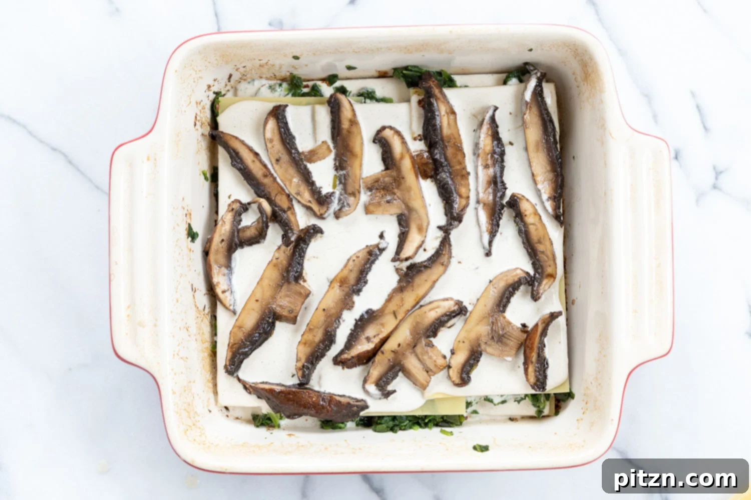 Decadent Vegan Mushroom Lasagna 10 Building the layers of creamy vegan mushroom lasagna: noodles, sauce, and baked mushrooms